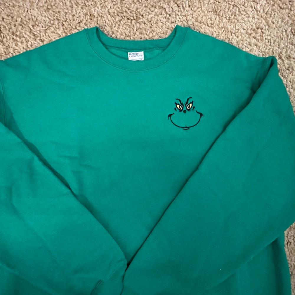 Green sweatshirt with a left chest embroidered Grinch.